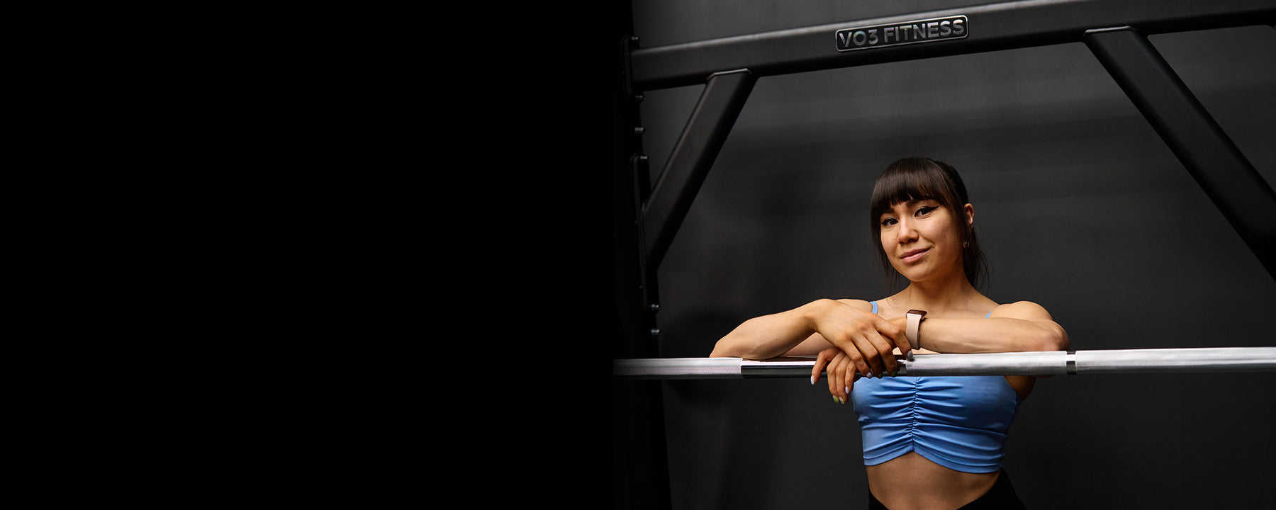 Woman in a VO3 Fitness gym beside commercial strength equipment